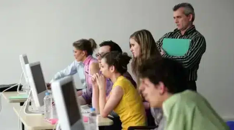 Online learners huddled in front of a computer screen